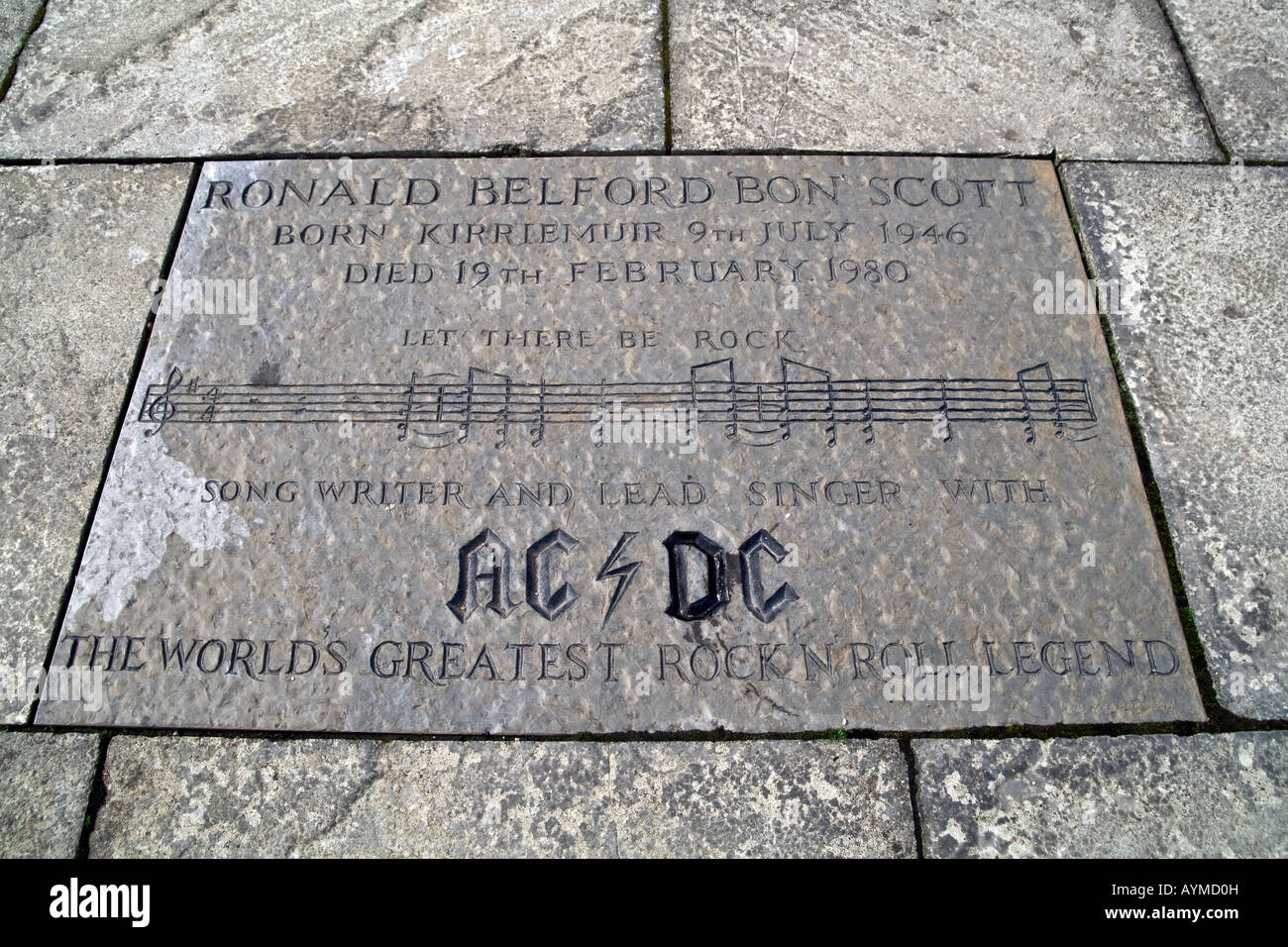 Let There Be Rock.Ronald Belford Bon Scott cantante della rock band AC/DC incisi in lastra di pietra nel centro della città di Kirriemuir Regno Unito Foto Stock