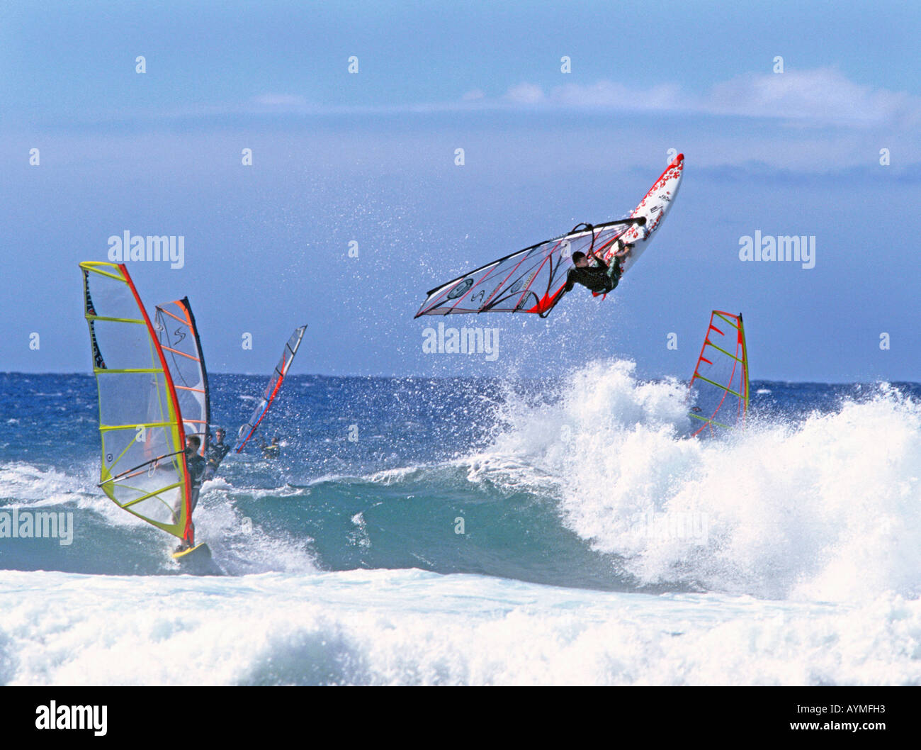 Un vento surfer lancia off il surf sulla costa di Maui, Hawaii. Foto Stock