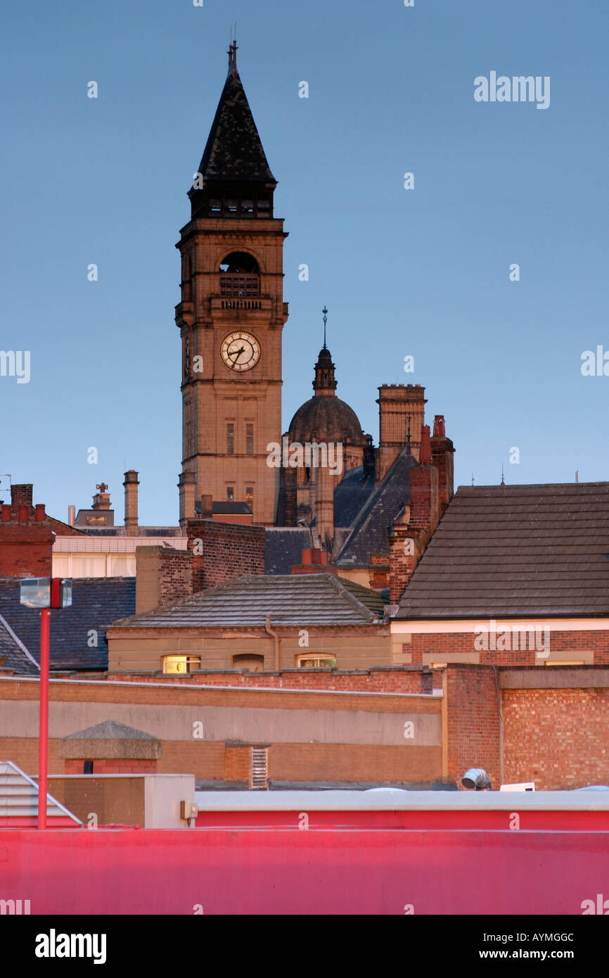Sole di mattina di catture la torre dell orologio del Municipio Wakefield con camini e tetti di uffici adiacenti in vista Foto Stock