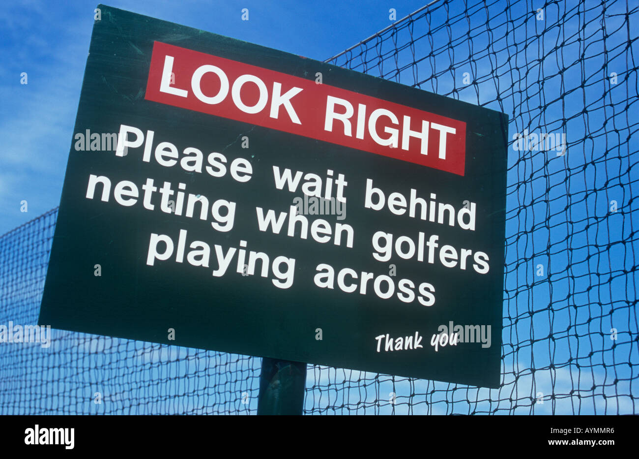 Segno sul sentiero pubblico accanto a rete di sicurezza precisando guardare a destra si prega di attendere alle spalle di netting quando i golfisti giocando attraverso la ringrazio Foto Stock