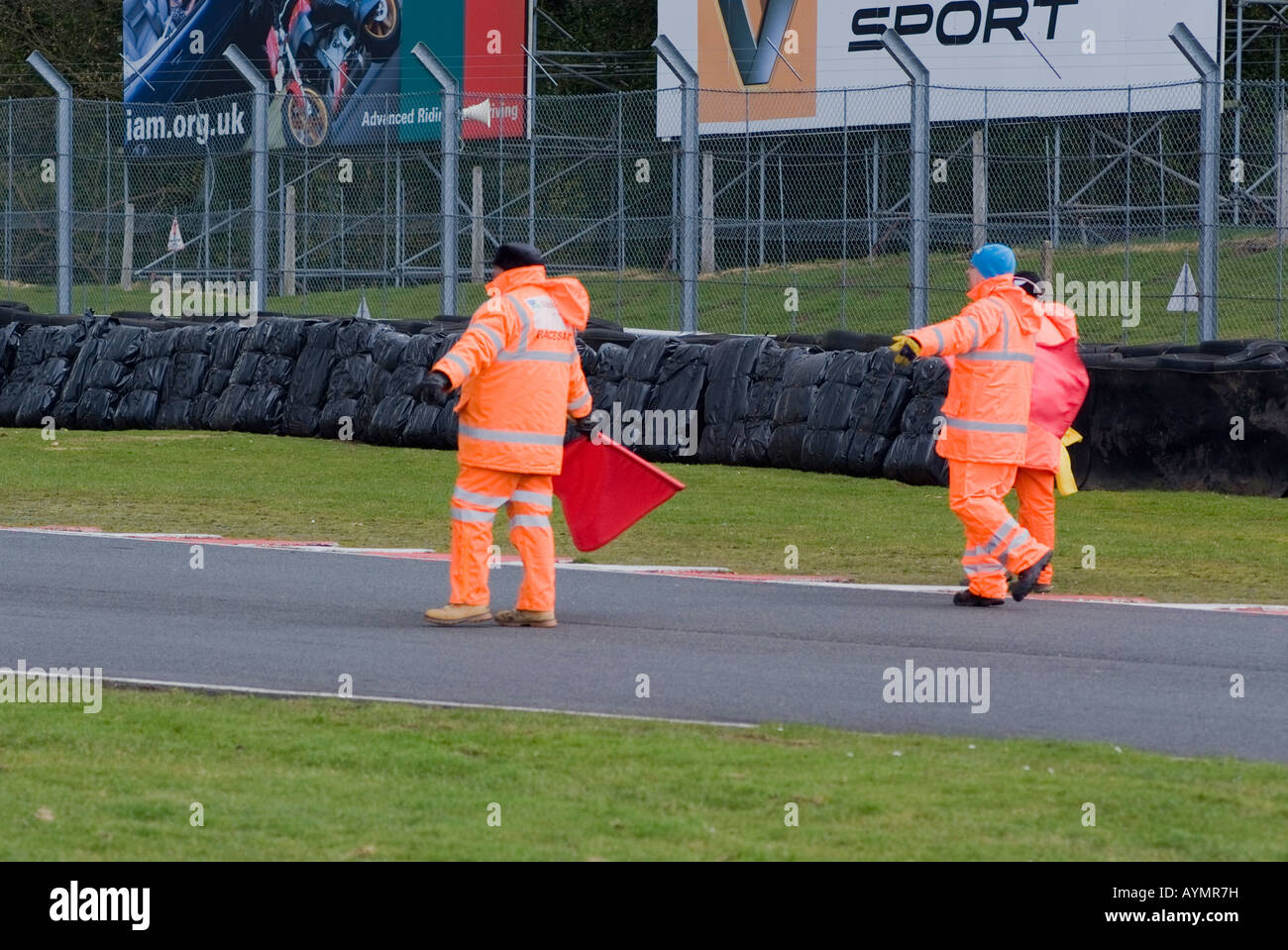 Via Marshalls con bandiere rosse del circuito di compensazione del traffico dopo la gara di moto ad Oulton Park Motor Racing via CHESHIRE REGNO UNITO Foto Stock