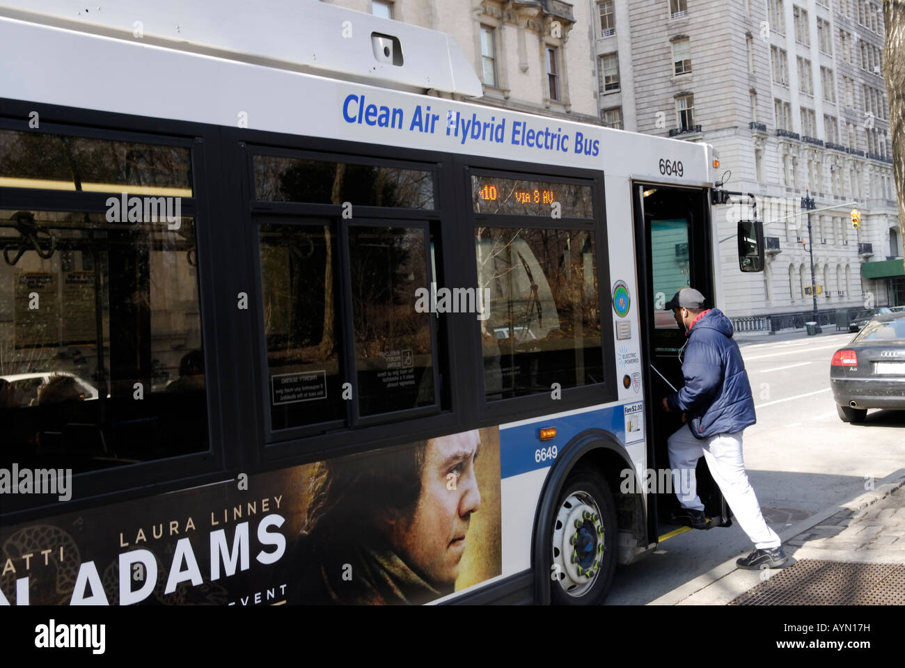 Persona di salire a bordo di un gas ibrido elettrico bus sul suo percorso sulla Upper West Side di Manhattan Foto Stock