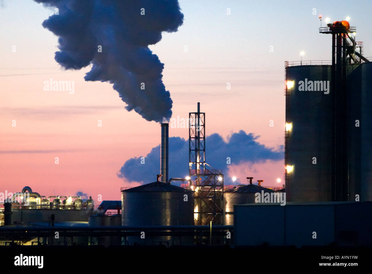 Un impianto di etanolo si stagliano contro un tramonto colorato. Foto Stock