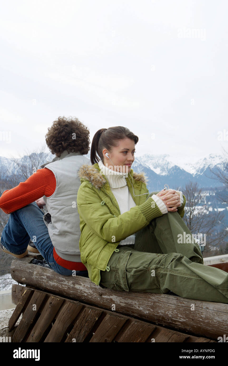 Giovane donna e uomo con capelli ricci seduta di schiena in un winterly paesaggio di montagna Foto Stock