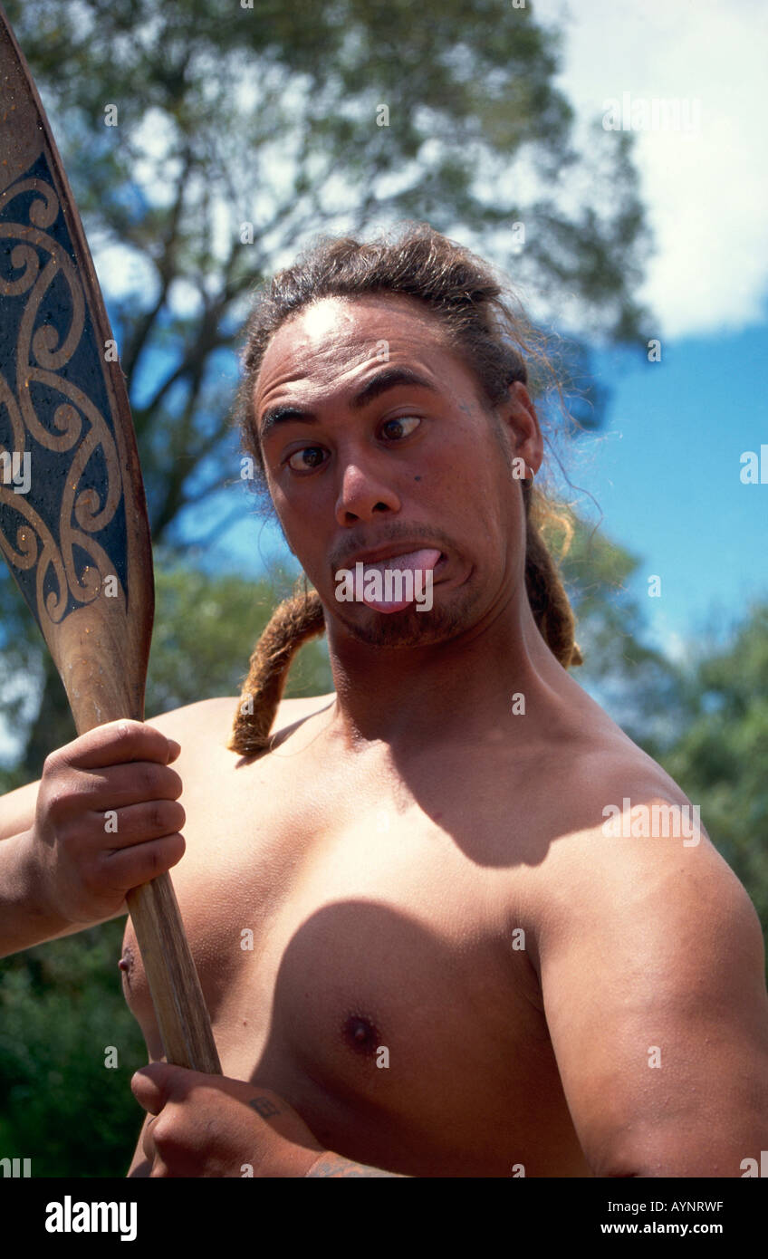 Un boggle eyed guerriero Maori con un gusto club e il suo tounge spuntavano come egli esegue un saluto tradizionale sulle rive del lago Rotorua Foto Stock