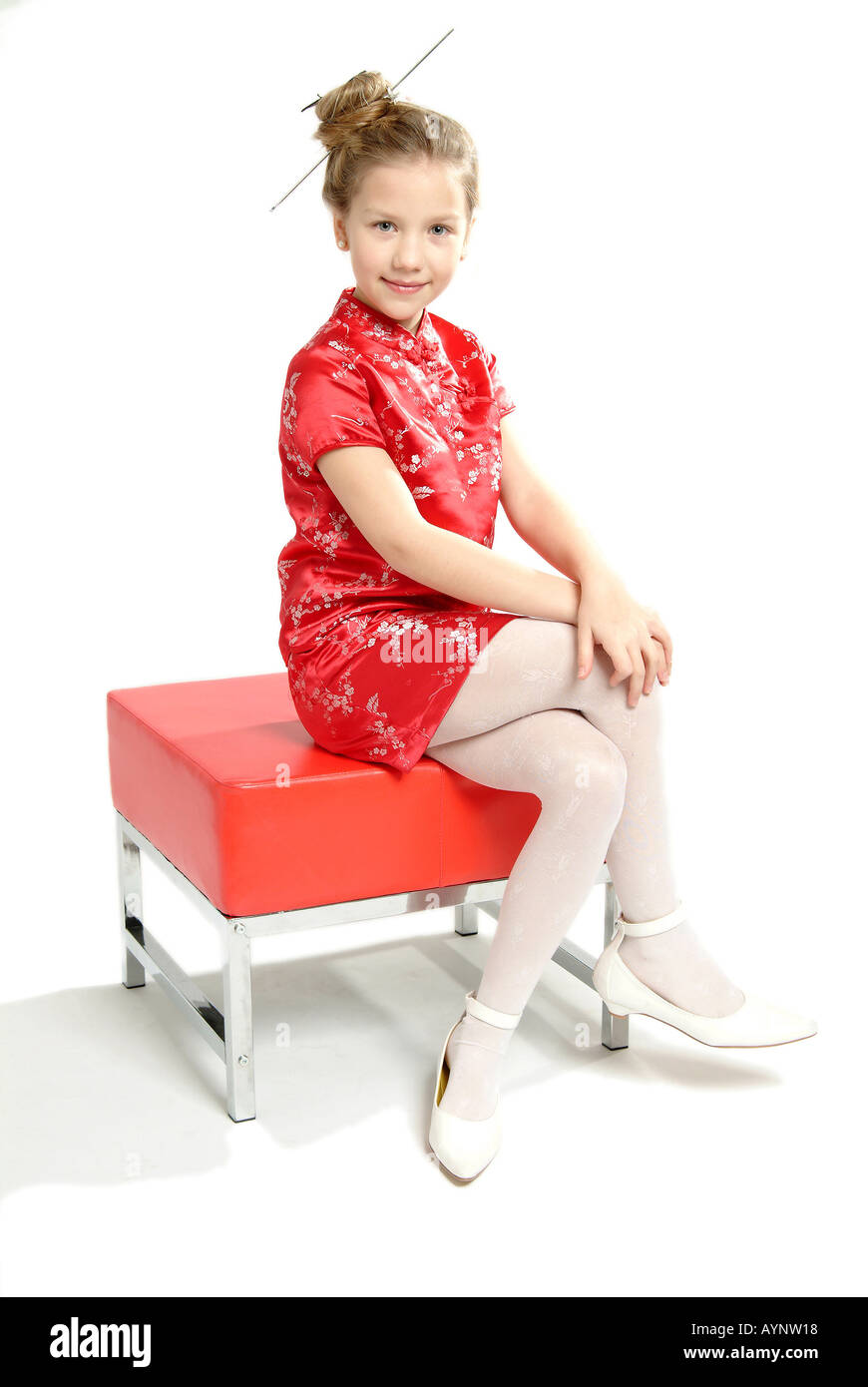 Zehnjaehriges Maedchen mit langen Haaren blondn und asiatischem Kleid Foto Stock