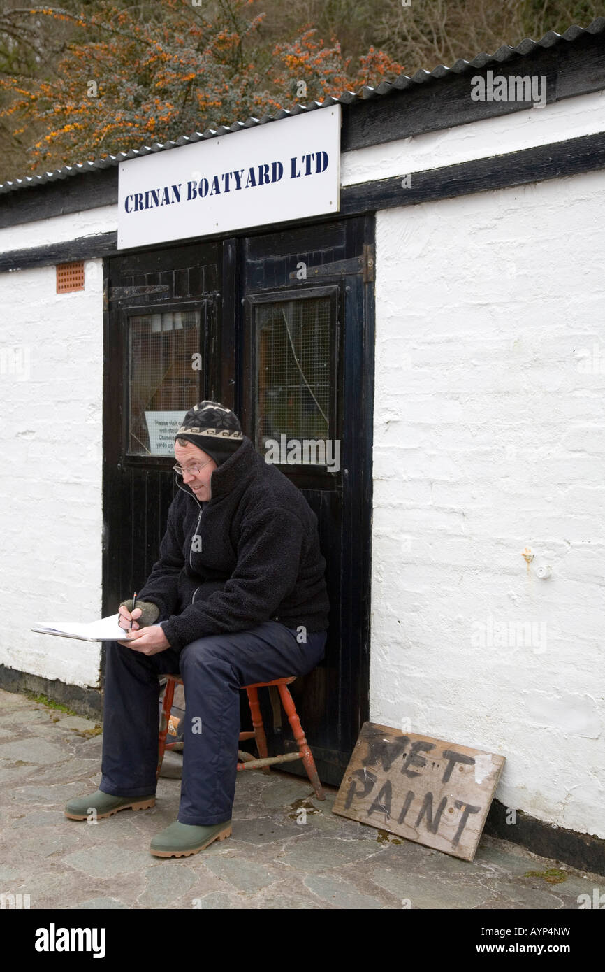 Wet segno di vernice e artista Fraser Campbell a serratura Crinan cantiere, Argyll Scotland Regno Unito Foto Stock