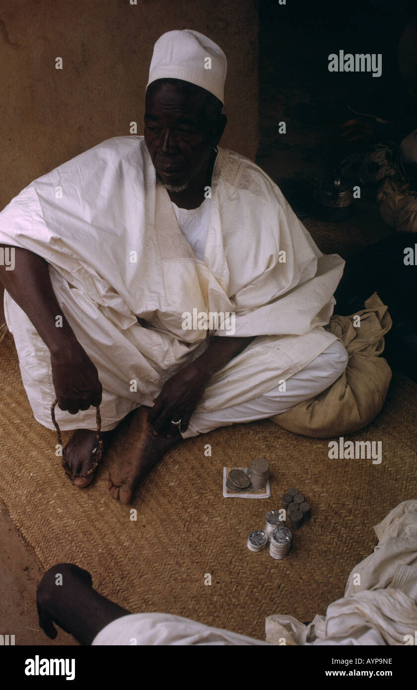 La Nigeria West Africa Mercati Kano persone maschio caricatore di denaro al mercato indossando white accappatoi di cotone e hat Foto Stock