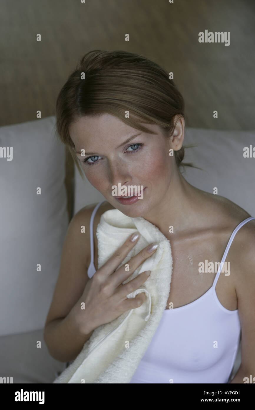 Una donna bionda tergi il suo corpo con un asciugamano Foto Stock