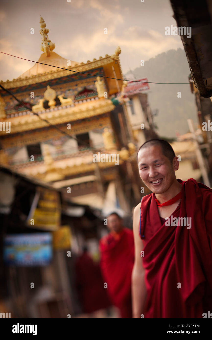 Un ritratto di un sorridente monaco tibetano in un villaggio street al tramonto. Foto Stock