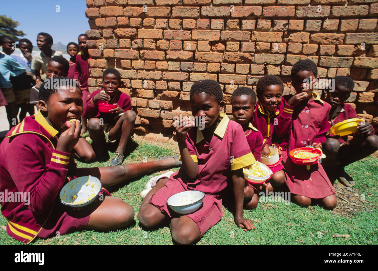 Scolaresche che mangiano il loro pranzo scolastico fornito da aiuti stranieri. Lesotho Foto Stock
