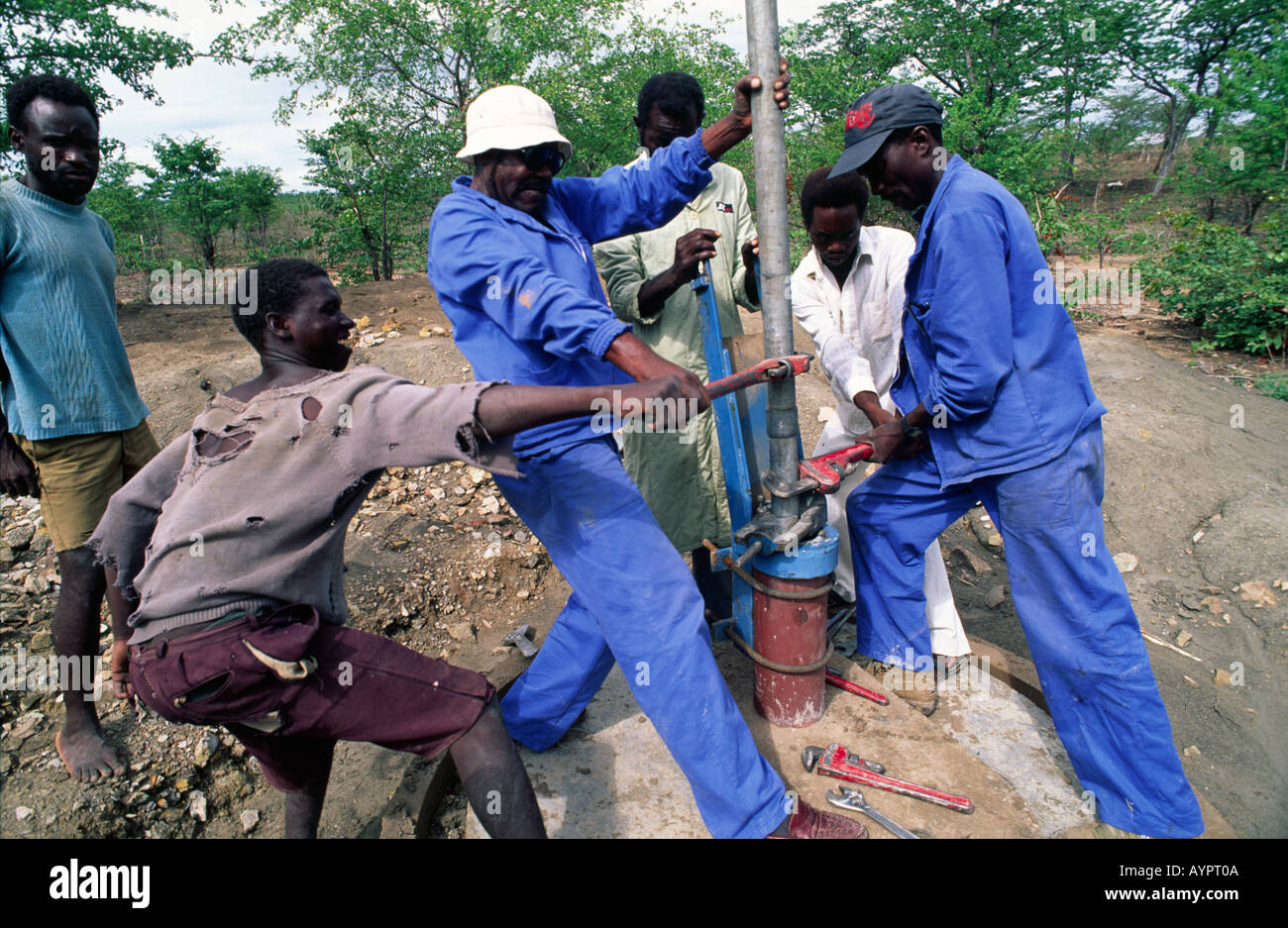 Tecnici dell'acqua che montano una testa ad una nuova pompa dell'acqua del villaggio nr. Binga nello Zimbabwe rurale Foto Stock