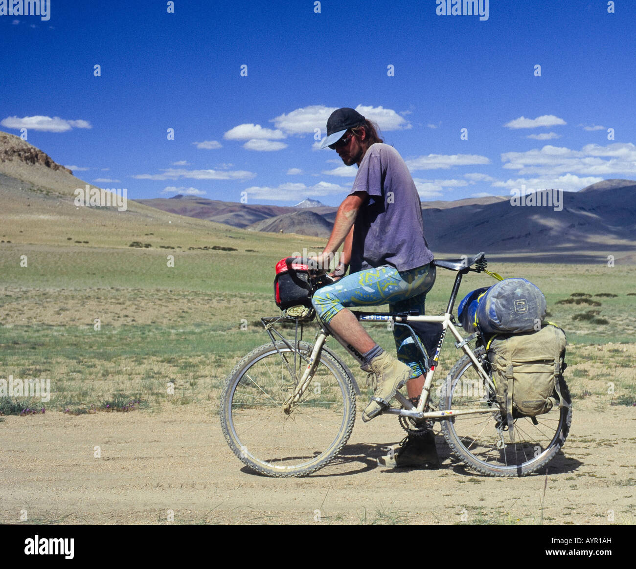 Ciclista su un sistema completamente caricato in mountain bike Escursioni in bicicletta lungo una strada sterrata, Himalaya, Ladakh, India Foto Stock