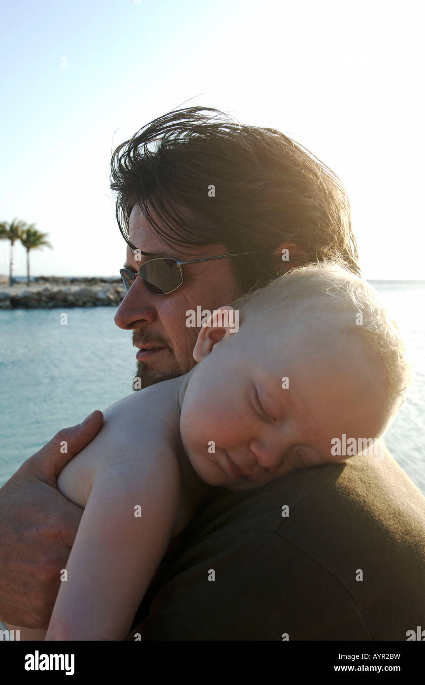 Antille olandesi Curaçao un bimbo che dorme nella braccia di suo padre Foto Stock