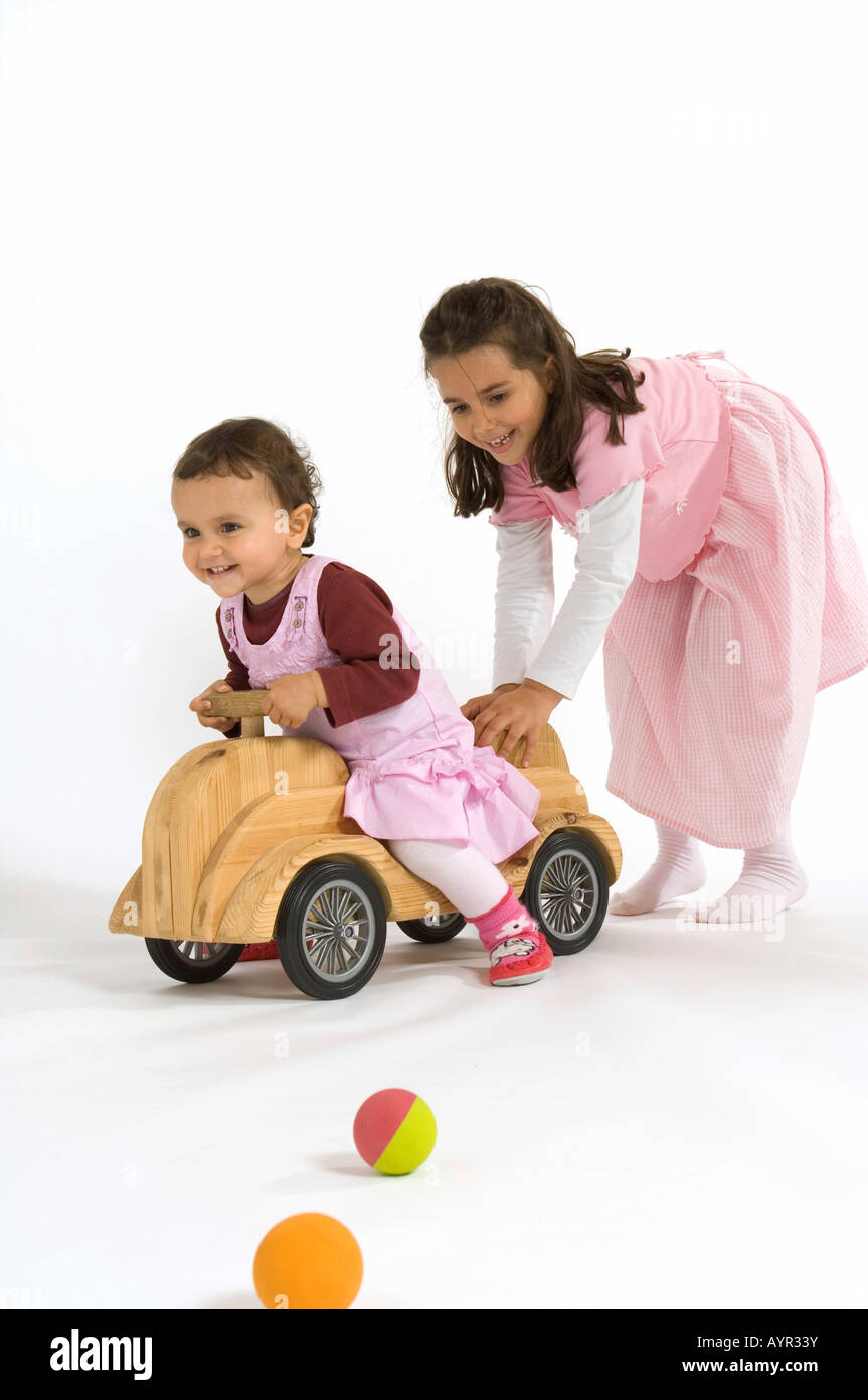 Due bambine, sorelle, giocando con auto in legno e sfere Foto Stock