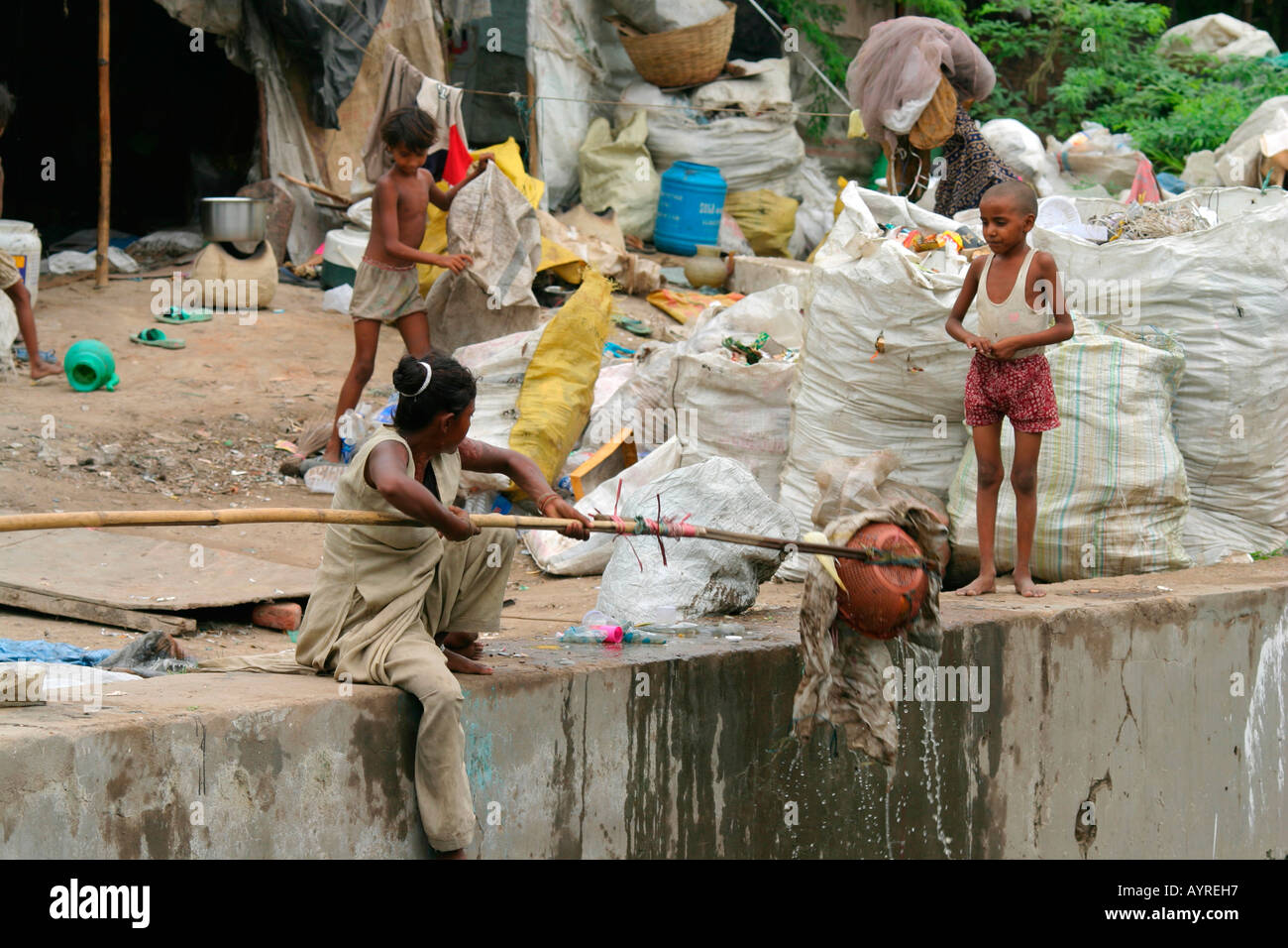 Cattive condizioni dei bambini che vivono tra i rifiuti in un ampio campo, Agra, India Foto Stock