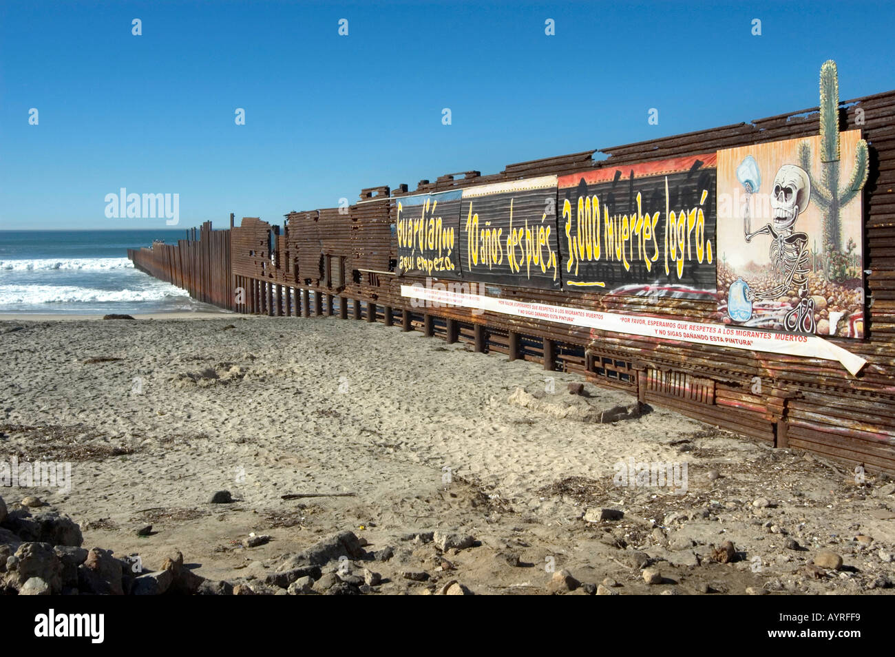 Stati Uniti messicani recinzione di confine in esecuzione nell'Oceano Pacifico con poster di avvertimento di morti accidentali di Tijuana, Messico Foto Stock