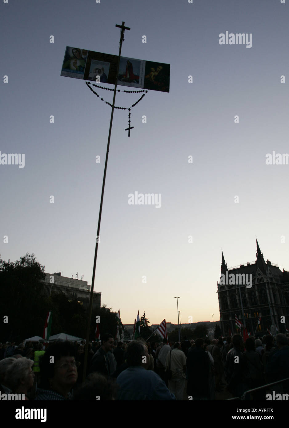 Silhouette di una croce contro un cielo notturno tenuto da manifestanti in piazza Kossuth a Budapest, Ungheria Foto Stock