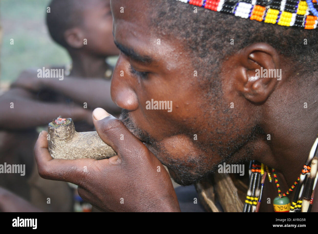 Africa Tanzania Lago Eyasi Hadzabe uomo fumo da un tradizionale tubo di argilla Foto Stock