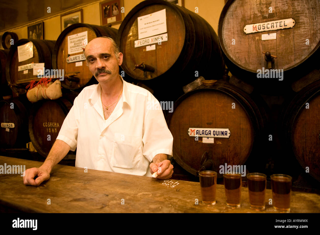 Cameriere Juan mantenendo la linguetta utilizzando Chalk sulla barra in Antigua Casa de Guardia, sherry barili dietro di lui, bodega in Málaga, Andalus Foto Stock