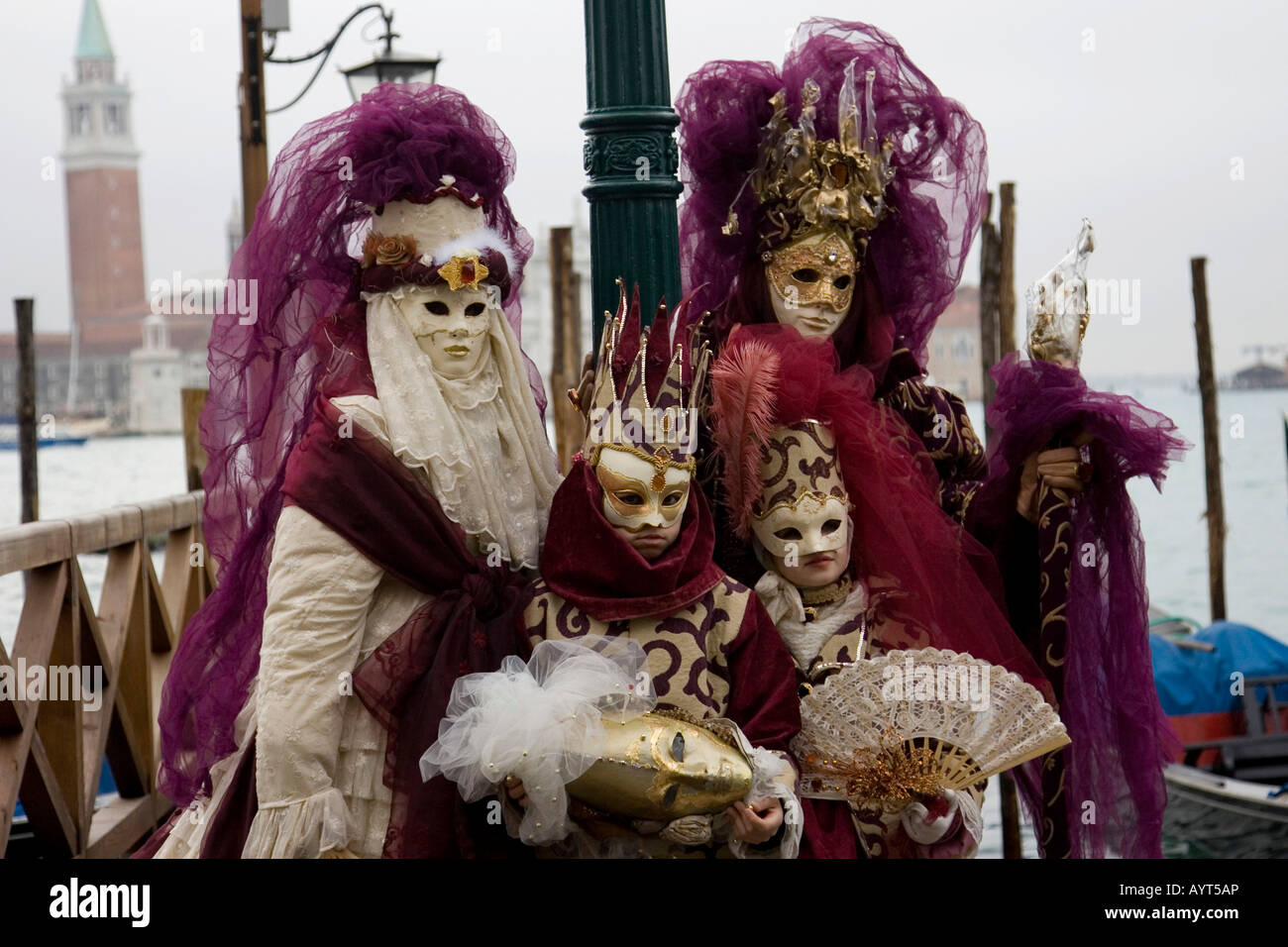 La famiglia di due adulti e due bambini, indossando il viola e oro costumi, il Carnevale di Venezia il Carnevale di Venezia, Italia Foto Stock