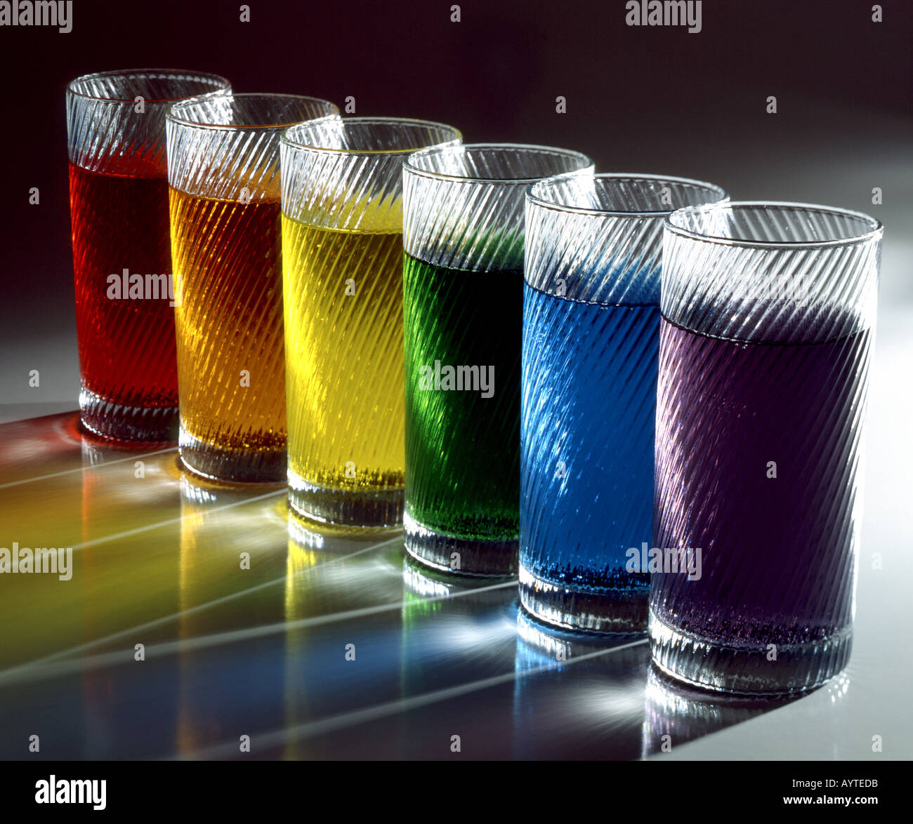 Sei bicchieri riempiti con acqua colorata con coloranti alimentari Foto Stock