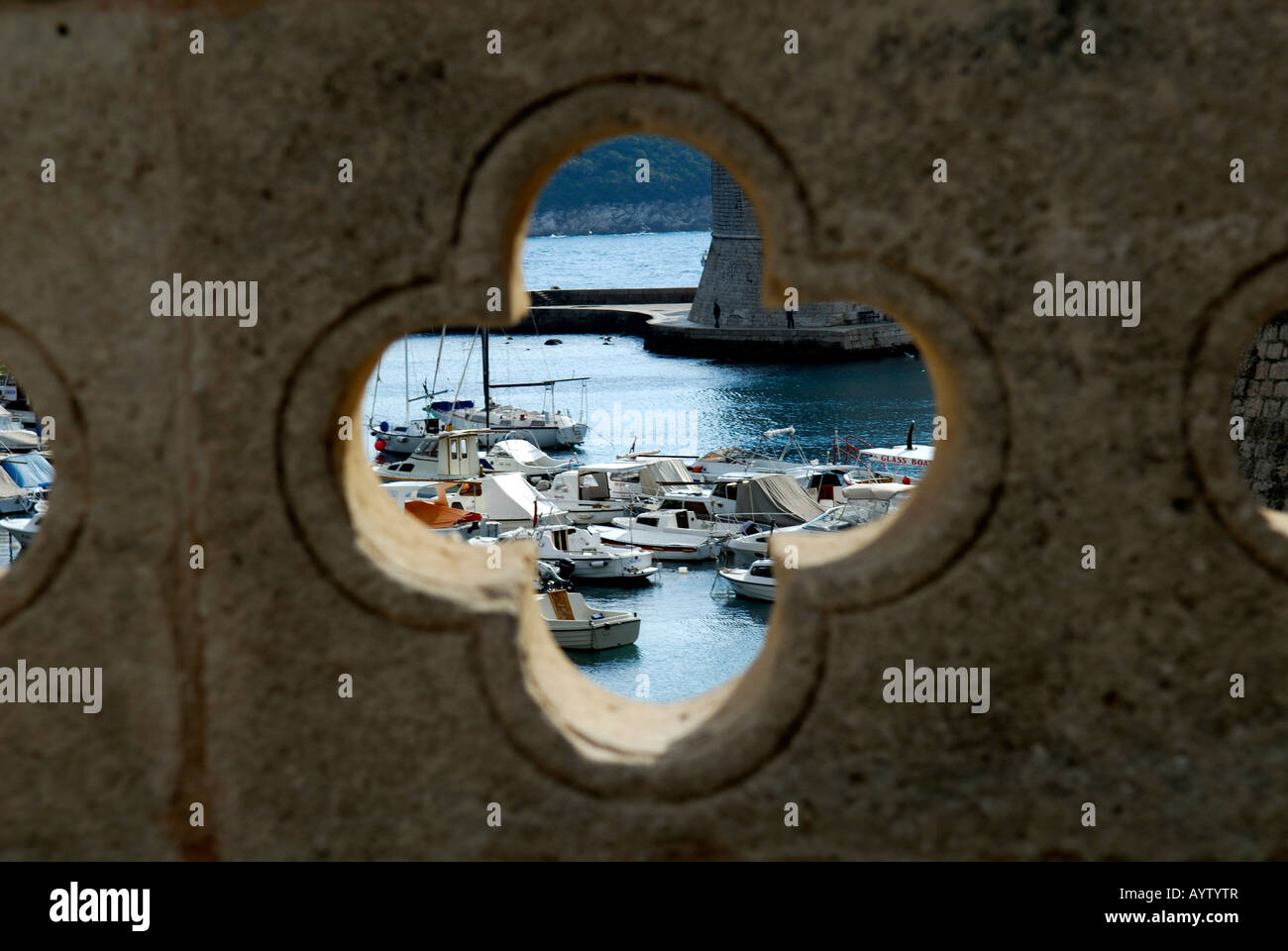 Vista delle barche nel porto quatrefoil attraverso aperture nella parete di ponte paese vecchio di Dubrovnik Croazia Foto Stock