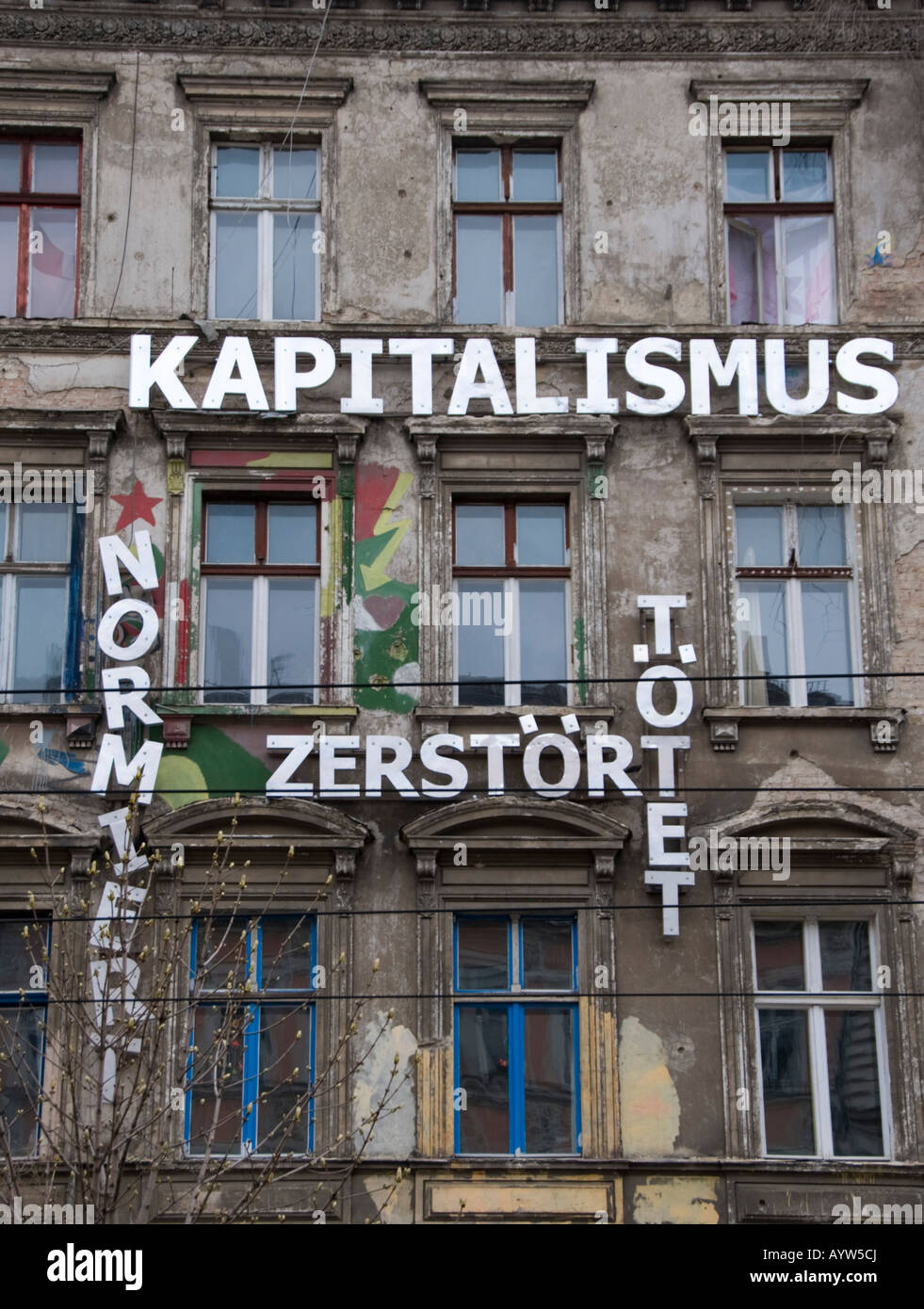 Indicazioni sulla ex Germania Est edificio appartamento dice il capitalismo uccide sulla Kastanienallee in Prenzlauer Berg di Berlino Germania 2008 Foto Stock