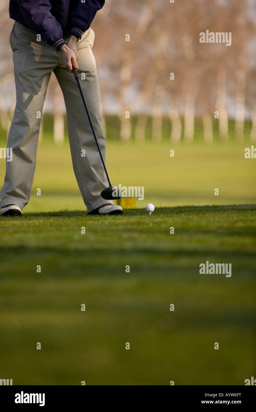 Il Golfer circa al tee off prendere un colpo su un corso di golf in Inghilterra Foto Stock