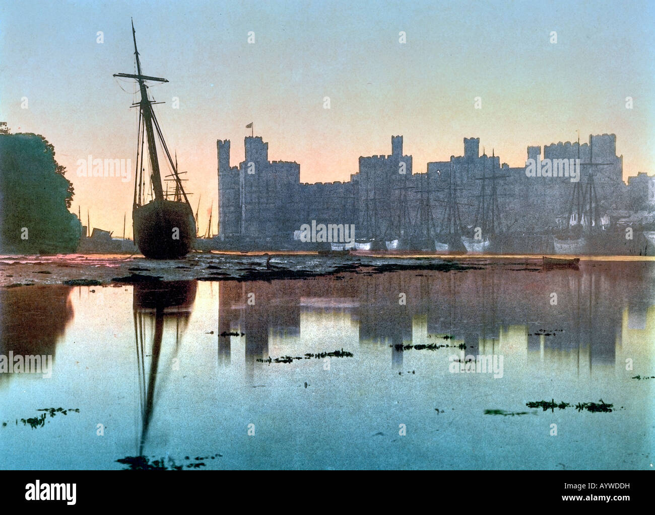 Caernarfon Castle al tramonto con barca a vela nel sito di primo piano Gwynedd North Wales UK Foto Stock
