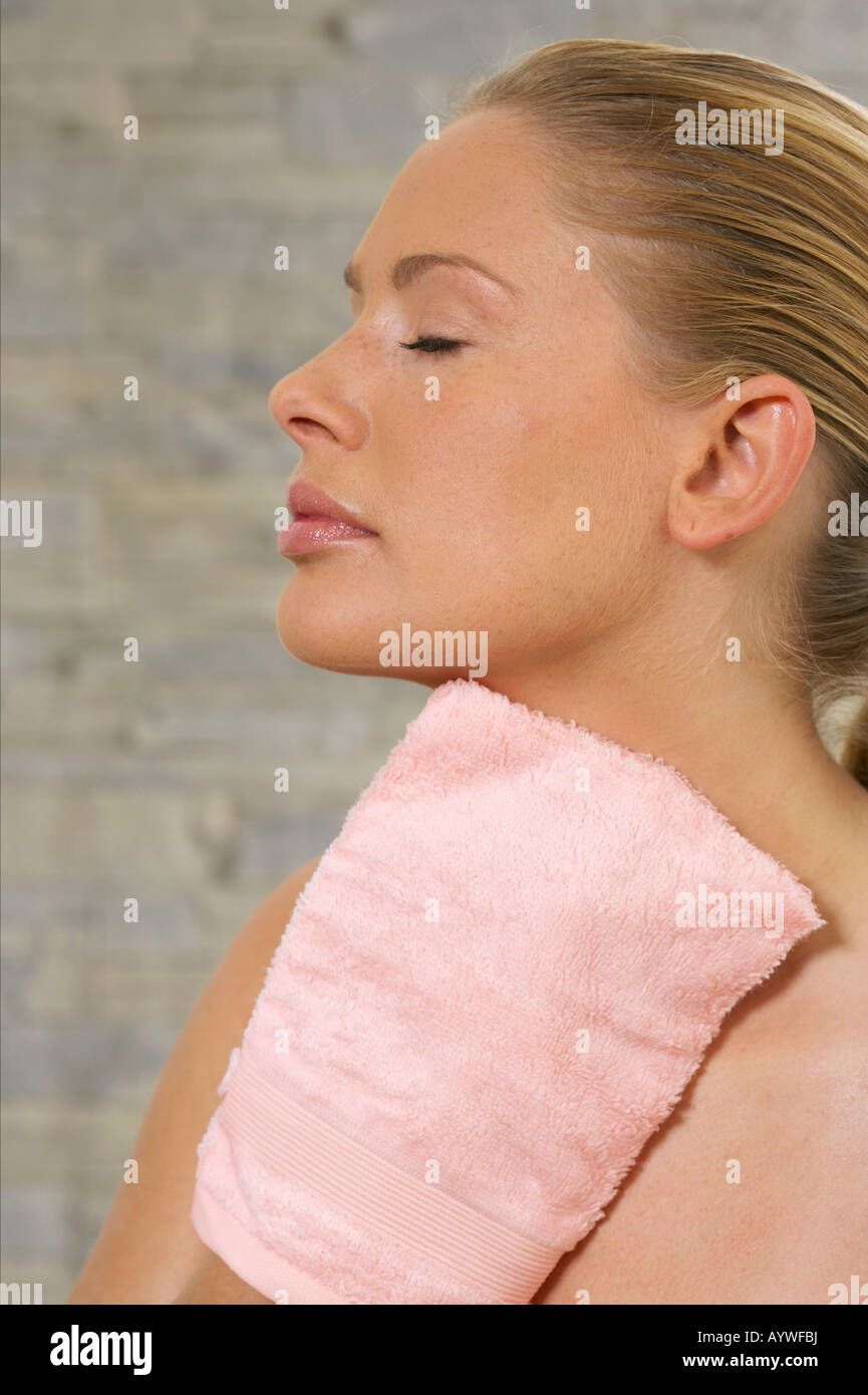 Giovane donna usando un guanto massaggio Foto Stock