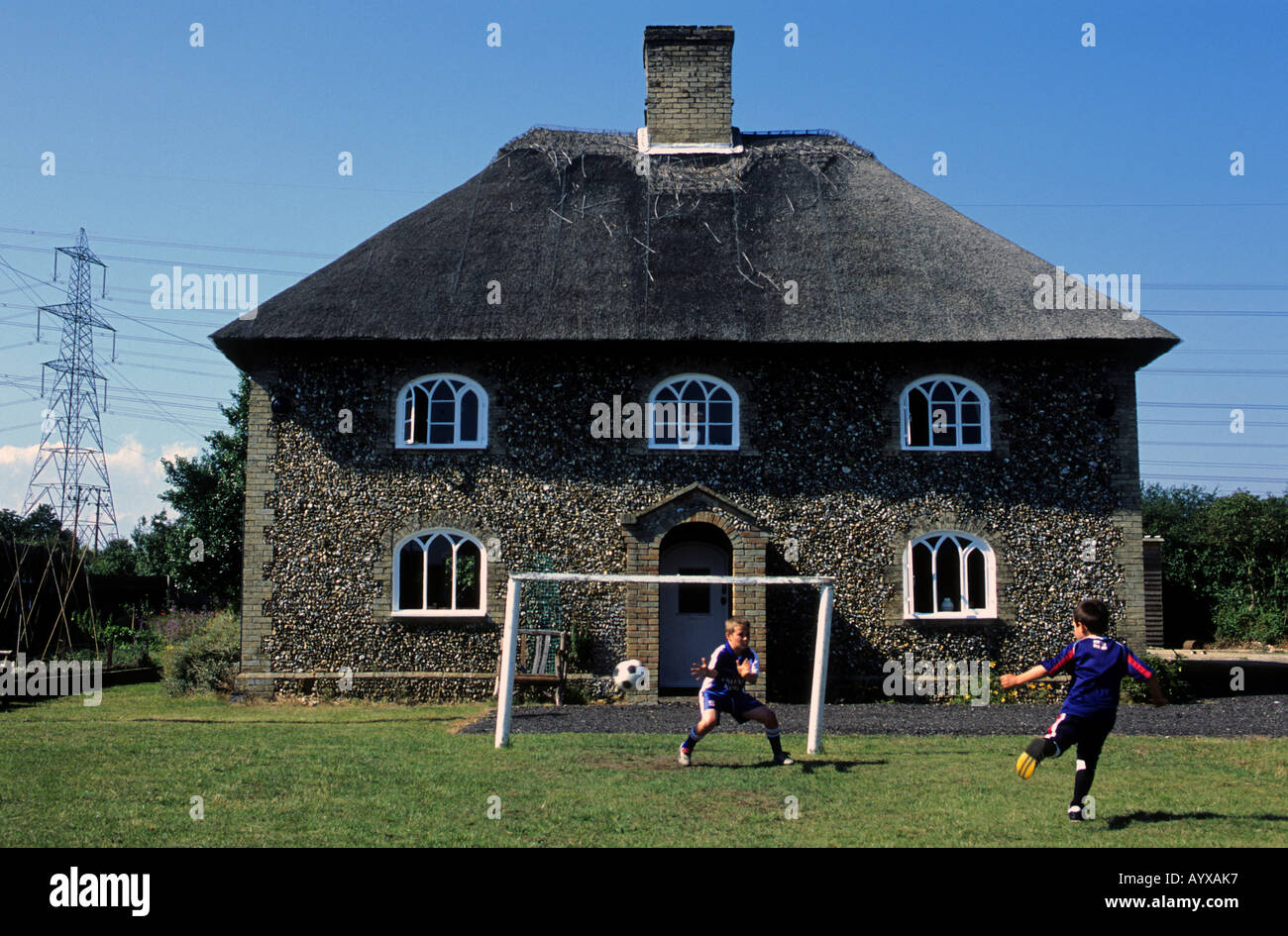 I bambini giocando una partita di calcio nel giardino della loro casa in Suffolk, Regno Unito. Foto Stock