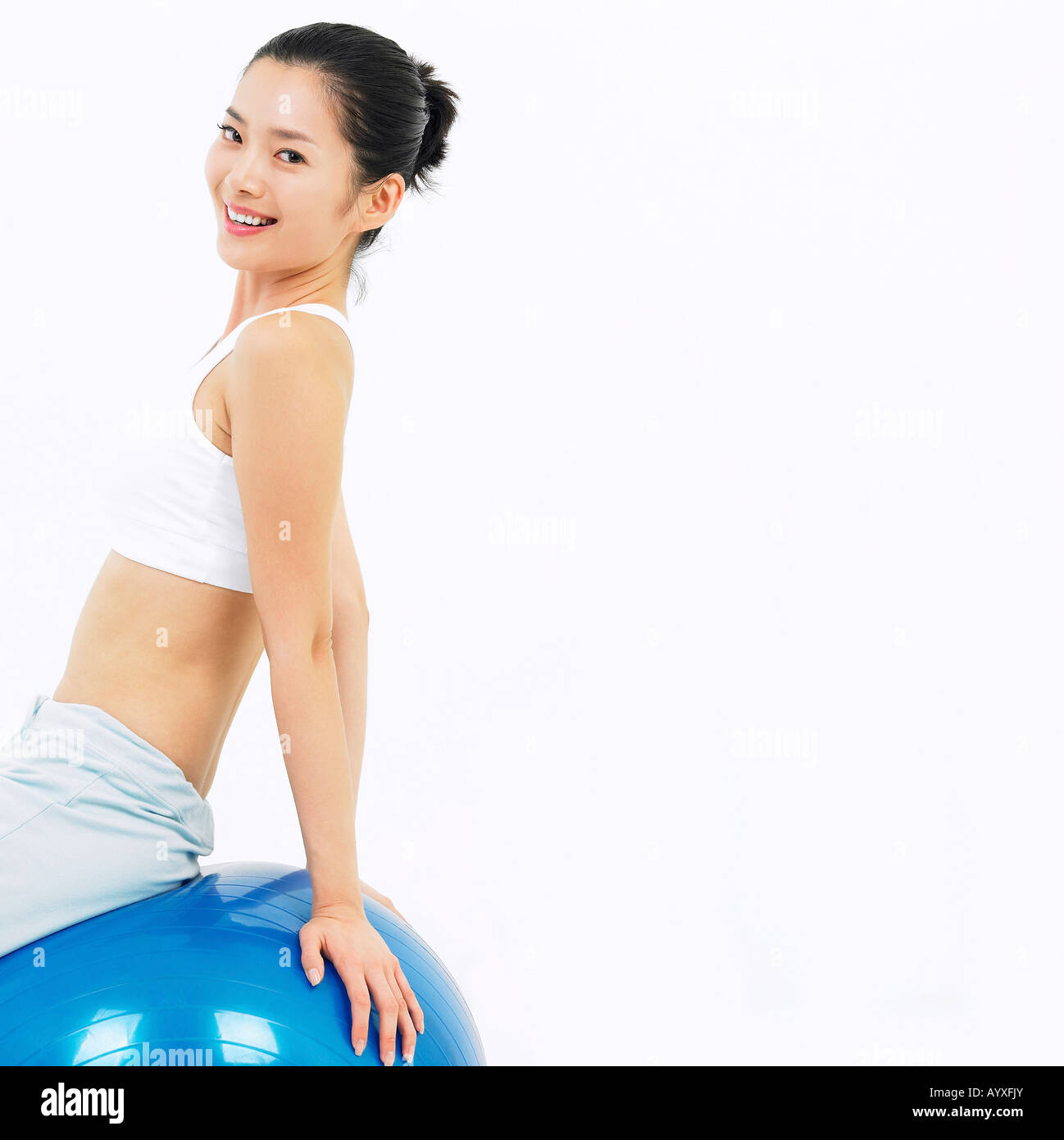 Una donna allungando su una sfera blu Foto Stock