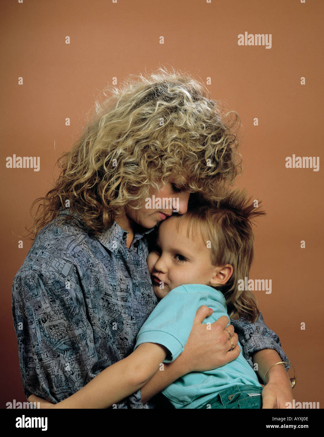 Kleiner Junge schmiegt sich an die Brust der Mutter Foto Stock