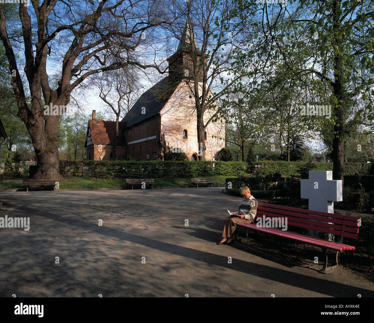 Kirche Sankt Annen, junge Frau sitzt auf einer Bank und liest, lesen, stimmungsvolle Ruhe, Berlin-Dahlem Foto Stock