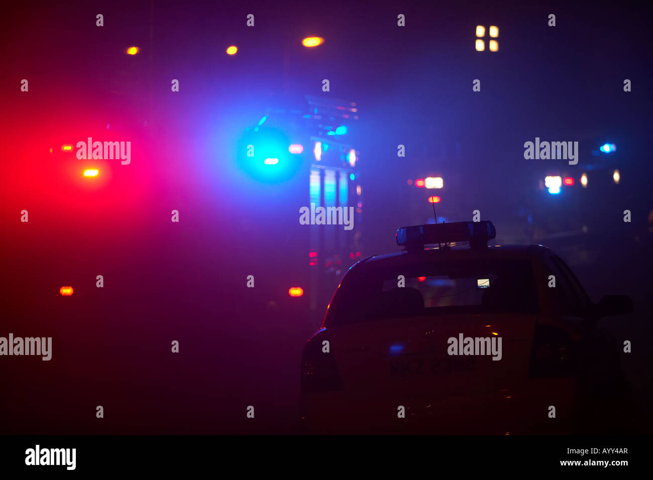 Irlanda del nord il fuoco e il servizio di soccorso gara di fuoco camion seduti al ciglio della strada con auto firechiefs in fumo Foto Stock