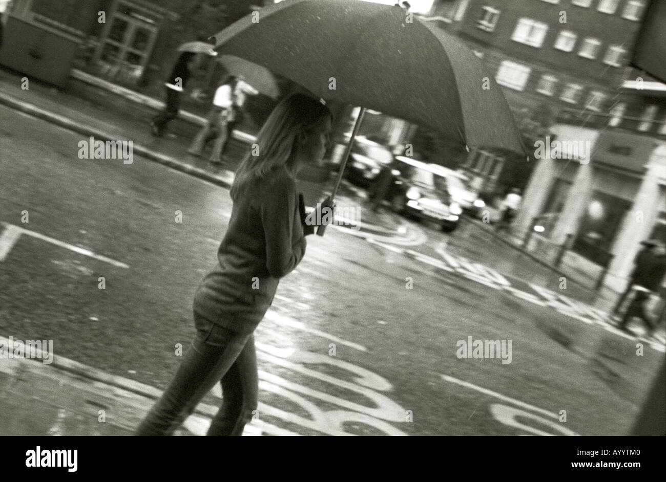 Giovane donna camminando sotto la pioggia Foto Stock