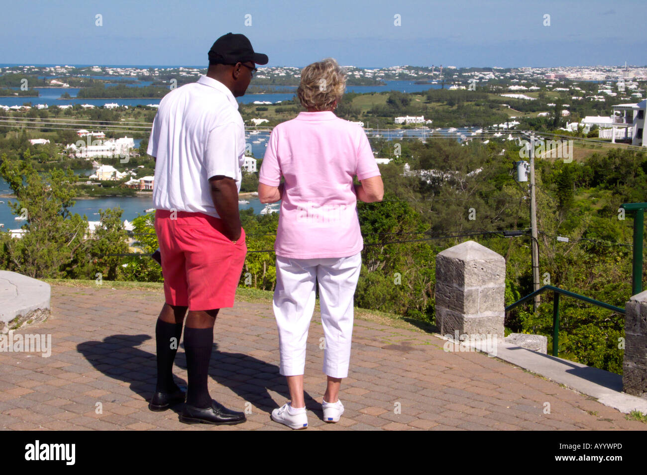 Un Bermudian guida turistica in rosa Bermuda con il suo cliente guardando la vista da Gibb sulla collina del faro verso Riddell's Bay, Bermuda Foto Stock