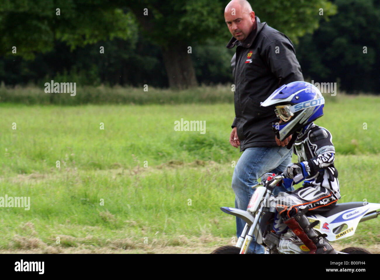 Piccola traccia di erba racing motociclista con il suo papà Foto Stock