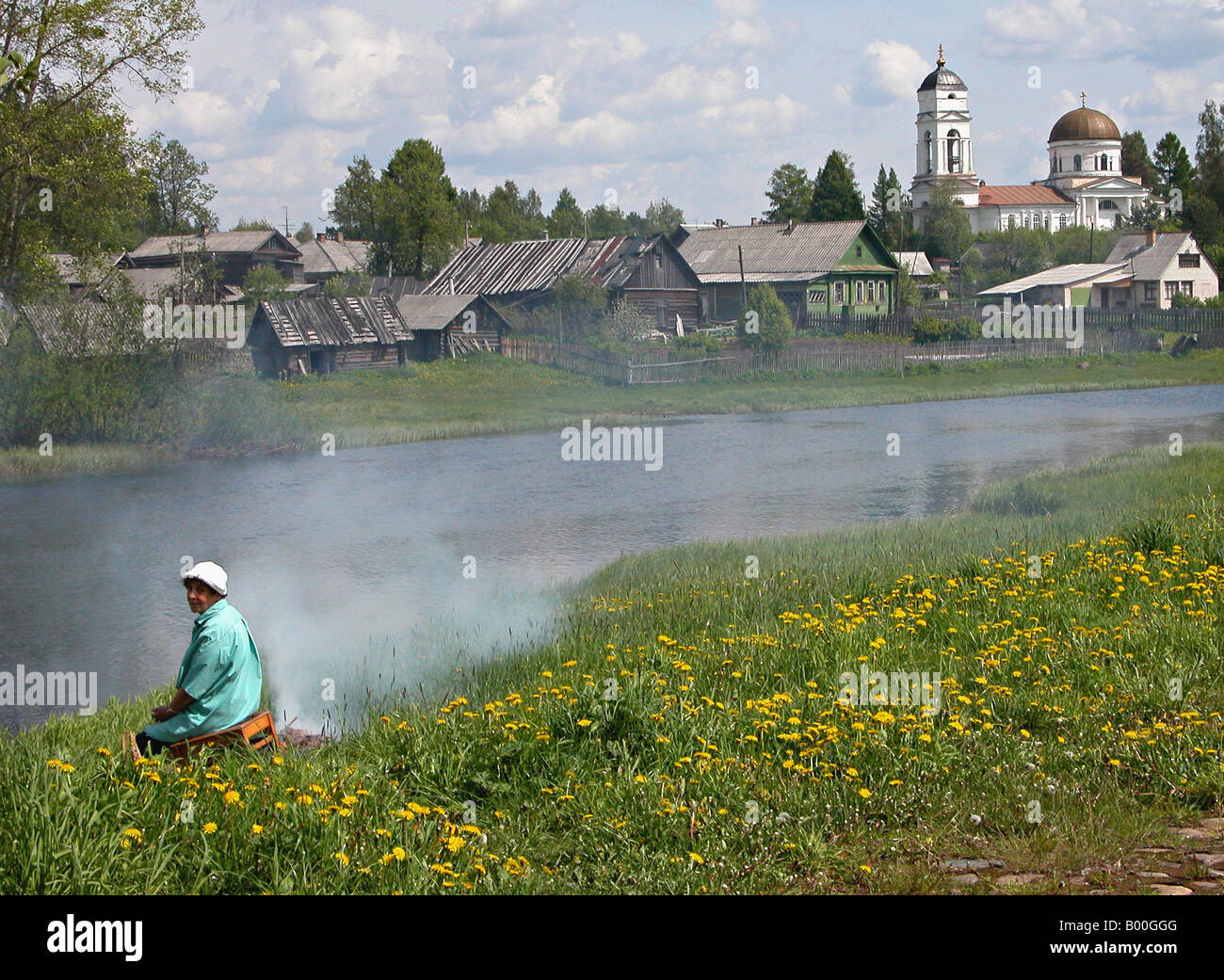 Una donna locale cottura su riverside nel tradizionale villaggio russo Somino, regione di Leningrado, Russia Foto Stock