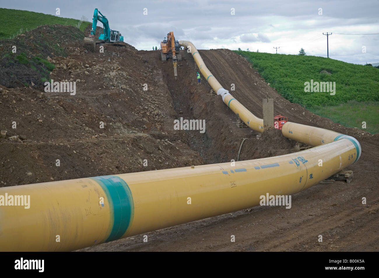 Un grande diametro di trasmissione del gas pipeline di acciaio devono essere accuratamente sagomato per adattarsi ai contorni del paesaggio ondulato. Foto Stock