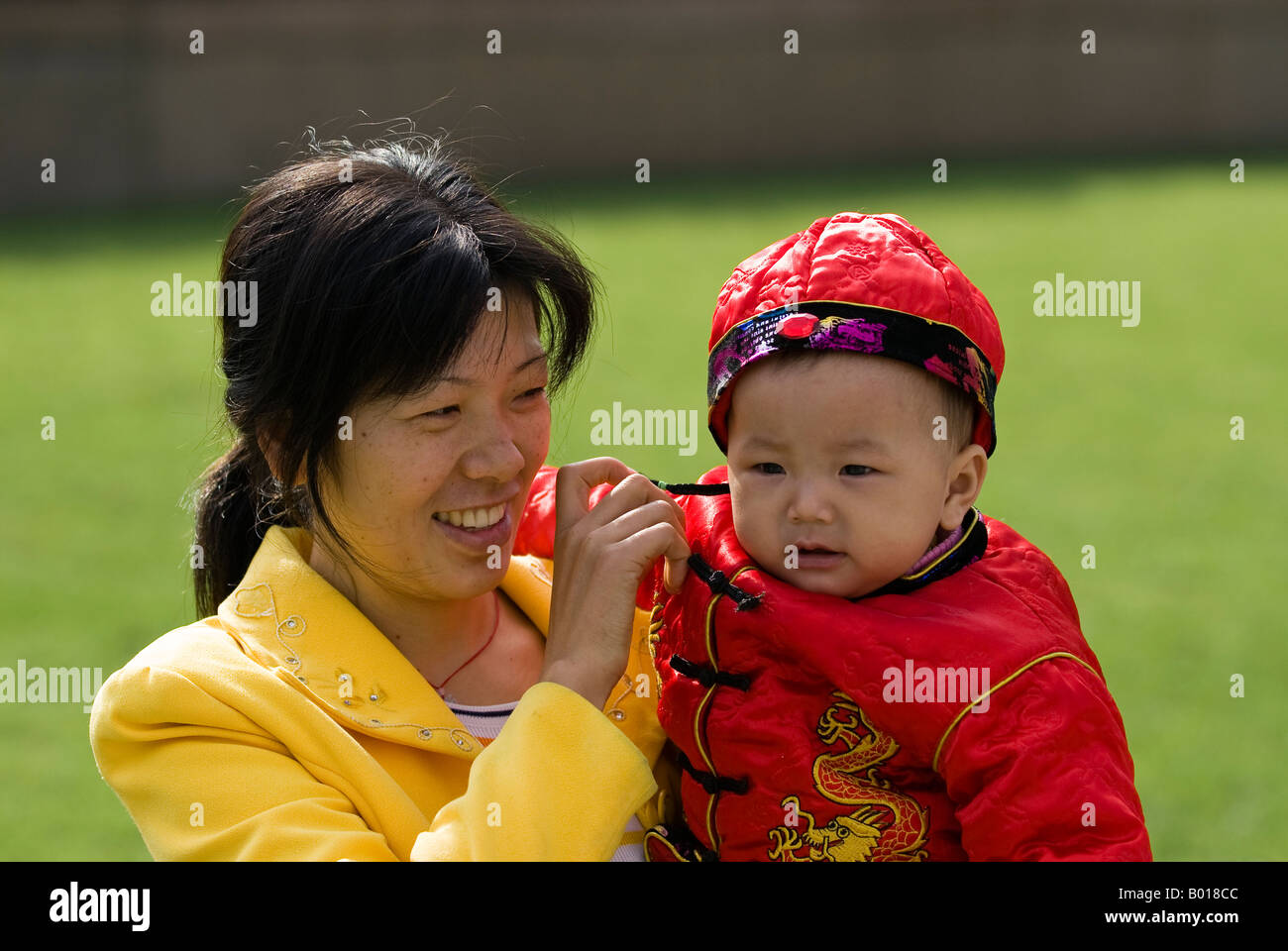 Mamma orgogliosa con baby boy in costume tradizionale, Renmin park, Shanghai, Cina Foto Stock