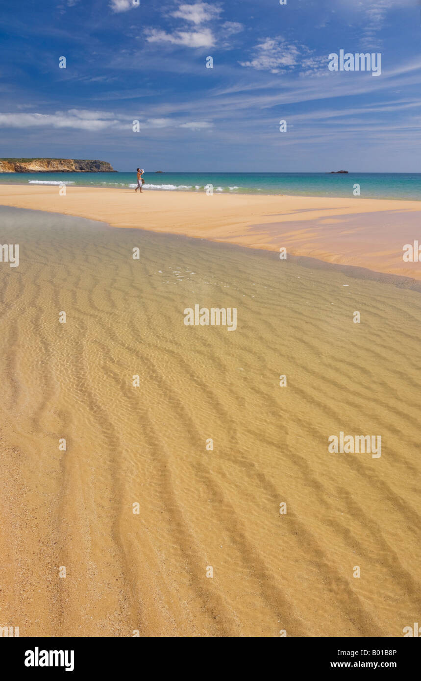 Giovane uomo in distanza sulla sabbia dorata della spiaggia di Martinhal Sagres Algarve Portogallo UE Europa Foto Stock