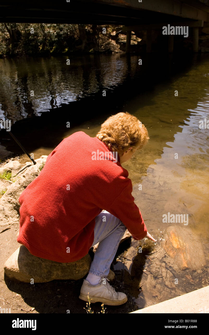 La donna caucasica (50-55) si rilassa al fiume Davidson campeggio nei pressi di Brevard North Carolina USA Foto Stock