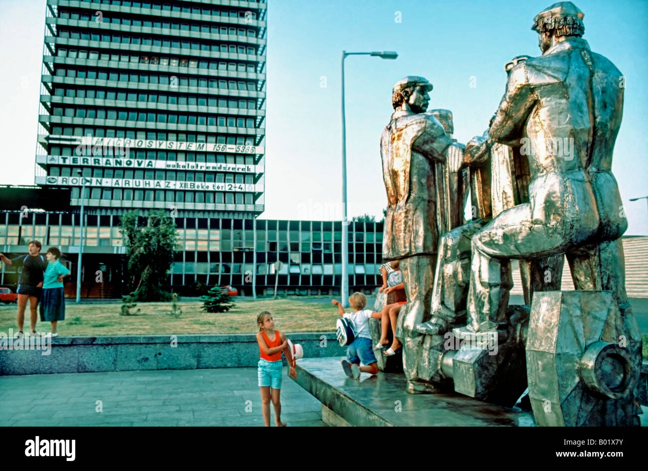 BUDAPEST UNGHERIA, bambini che giocano con i genitori in piedi da Socialista Public Art Modern Sculpture in una piazza pubblica, anni '1990 Foto Stock