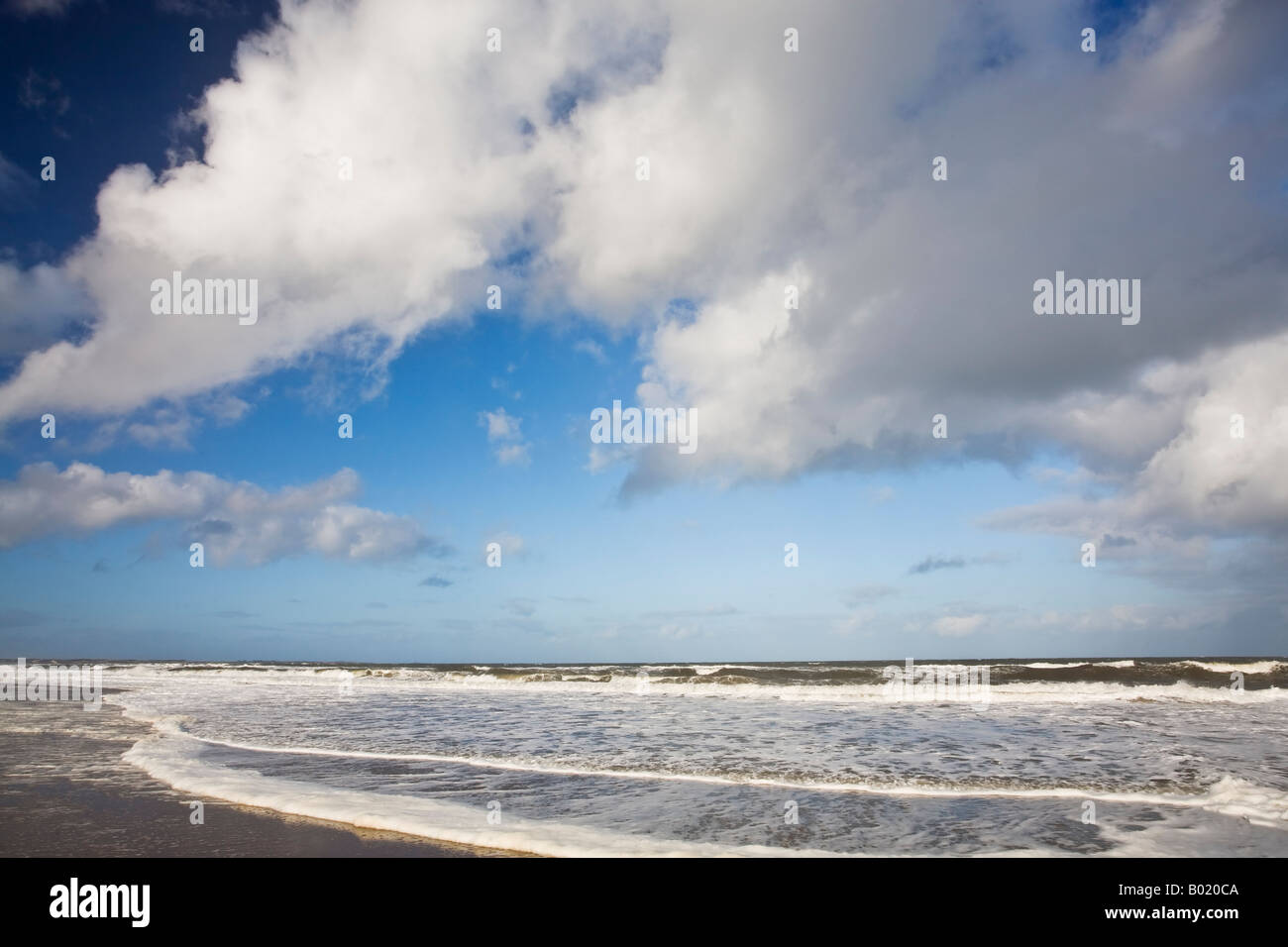 Le nuvole in un cielo blu al di sopra della marea in arrivo su Druridge Bay sulla costa Northumbrian, Northumberland, Inghilterra Foto Stock