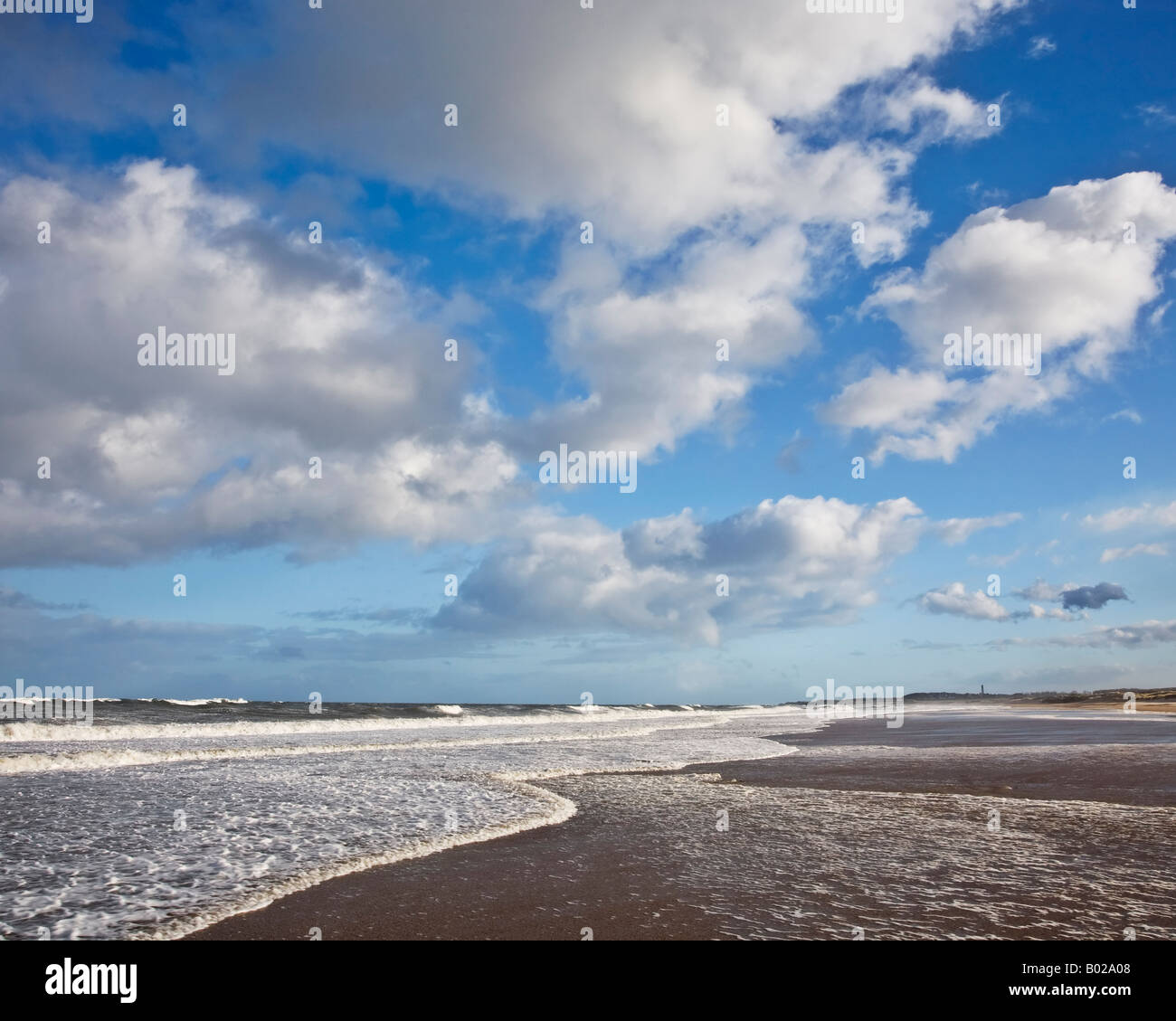 Le nuvole in un cielo blu al di sopra della marea in arrivo su Druridge Bay sulla costa Northumbrian, Northumberland, Inghilterra Foto Stock