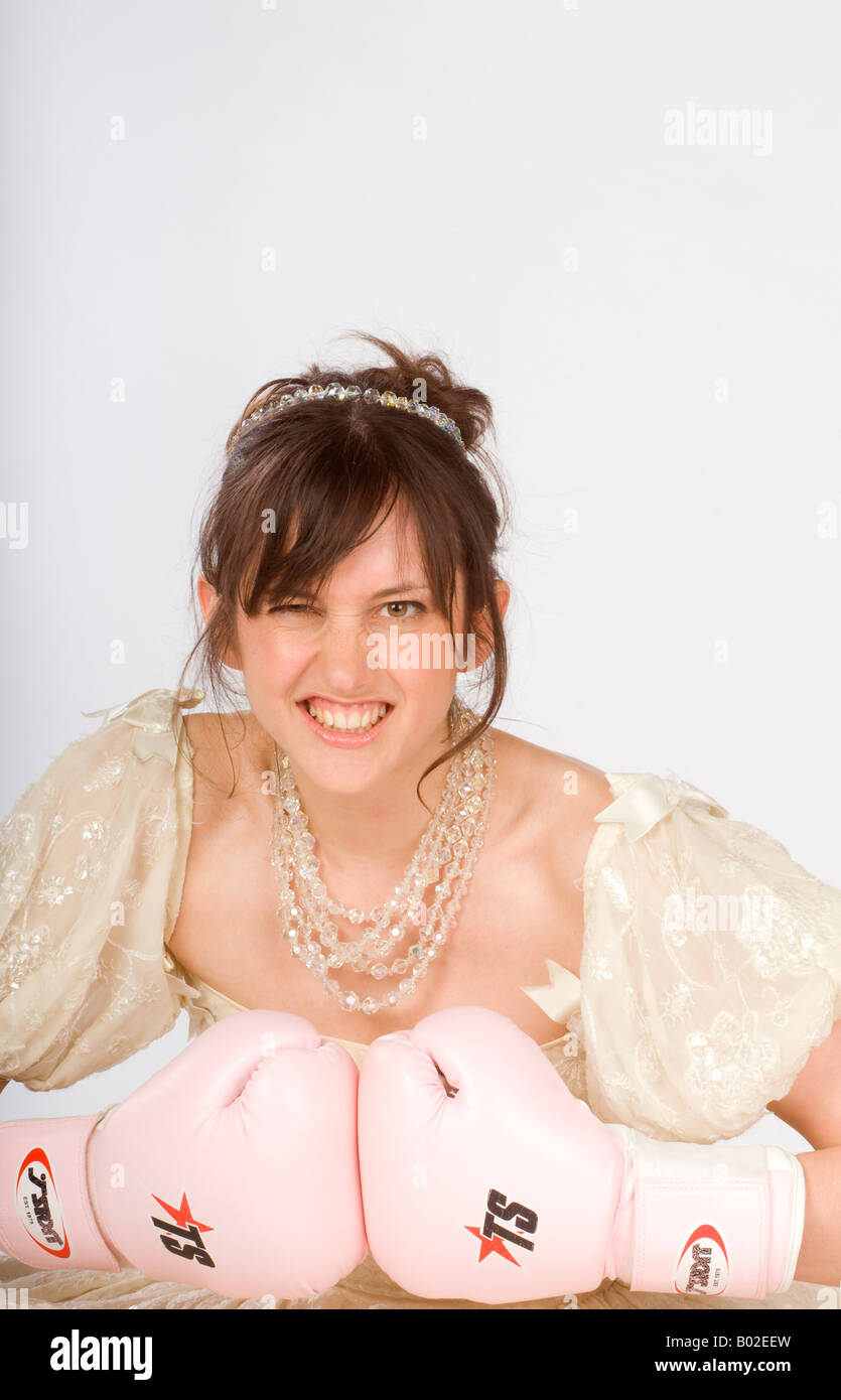 Una sposa rosa indossa guantoni da pugilato in una scherzosa guardare accordi prematrimoniali e sposarsi. Foto da Jim Holden. Foto Stock