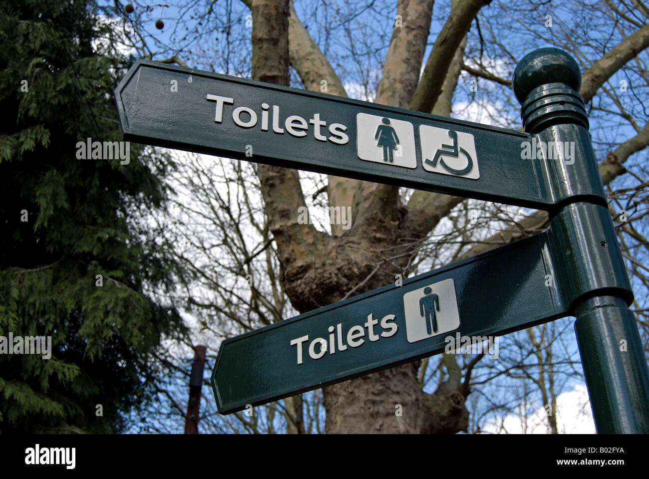 Due segni fissata ad un cartello per la mens, womens e bagni per disabili, si trova a East Sheen cimitero, Surrey, Inghilterra Foto Stock