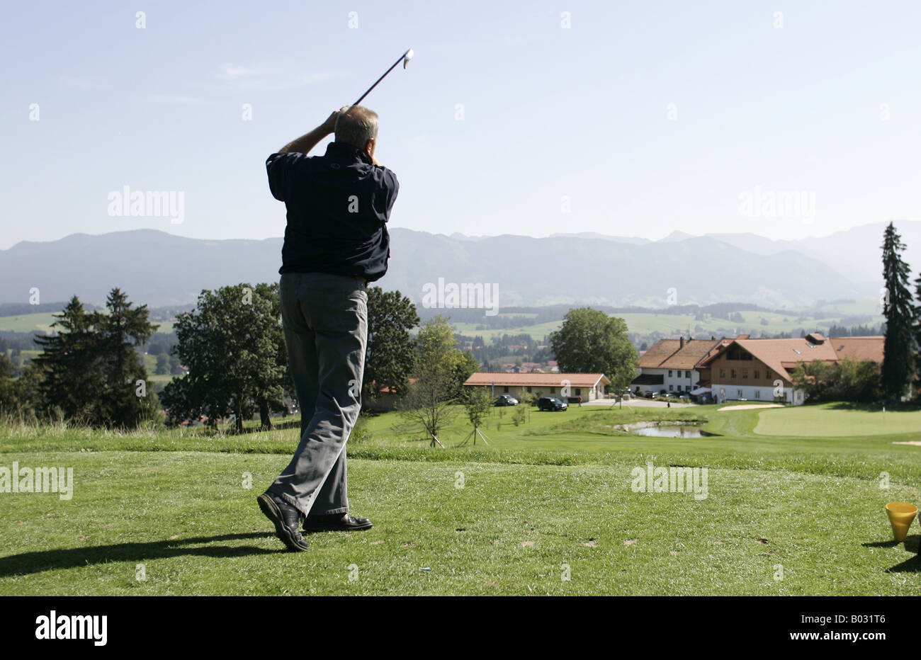 Il Golfer rinvio off avvicinando foro 18 vicino al clubhouse. Foto Stock